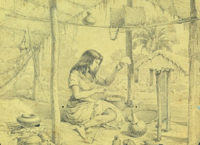 Desenho. Mulher indígena de vestido, sentada no chão de uma palhoça, puxando fio de um chumaço de algodão. À sua volta um tear e utensílios de barro.