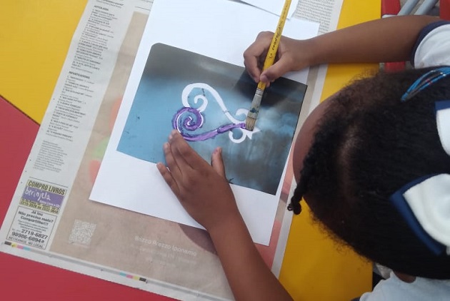 Brincadeiras Afrobrasileiras menina negra com laço desenha ave sankofa em aquarela